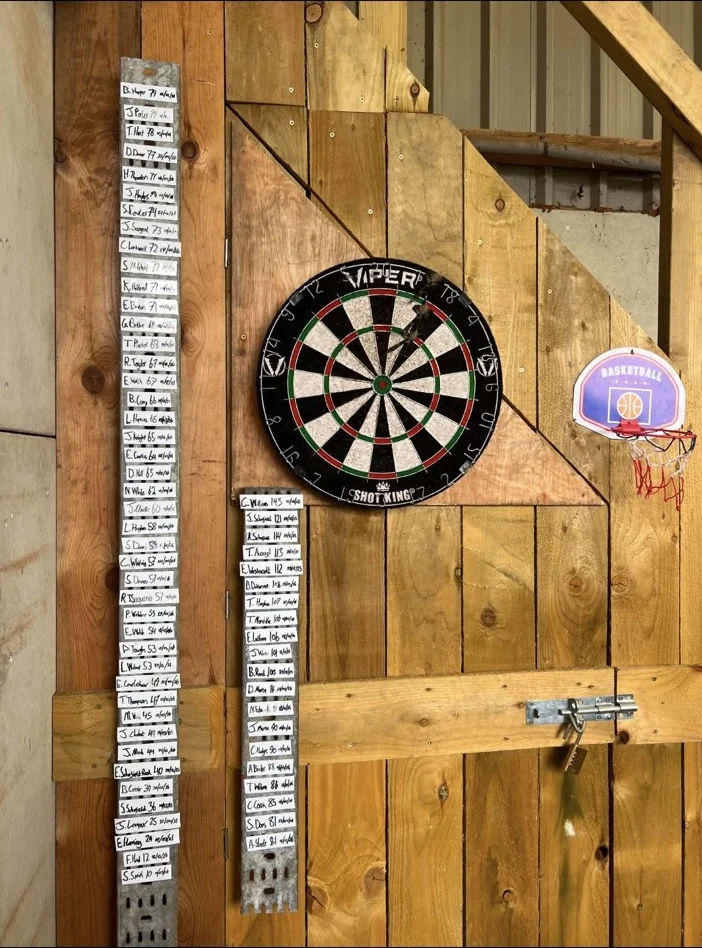 JMC darts board and handwritten leaderboard at the workshop
